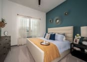 Thumbnail 22 of 47 - a bedroom with a bed and a blue wall and a window