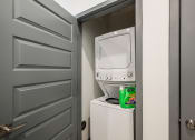 Thumbnail 25 of 47 - a small laundry room with a white washer and dryer and a gray door