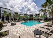Thumbnail 37 of 47 - a swimming pool with palm trees in front of apartment buildings