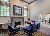 Thumbnail 10 of 33 - a living room with blue chairs and a fireplace