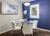 Thumbnail 3 of 33 - a dining room with blue walls and a table with white chairs