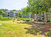 Thumbnail 29 of 33 - a park with benches and trees in front of an apartment building