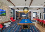 Thumbnail 28 of 78 - a game room with a pool table and a television at Altis Blue Lake, Lake Worth, Florida
