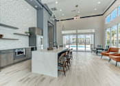 Thumbnail 7 of 31 - A modern kitchen with a marble island and wooden floors.