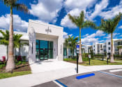 Thumbnail 1 of 78 - the leasing office at alis apartments building with palm trees at Altis Blue Lake, Lake Worth, FL, 33467