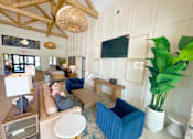 Thumbnail 4 of 23 - A living room with a blue couch and a television on the wall.