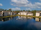 Thumbnail 44 of 49 - A fountain in the middle of a lake surrounded by houses.