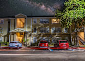 Thumbnail 40 of 49 - A building with a parking lot in front of it at night.