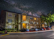 Thumbnail 42 of 49 - A building with a parking lot in front of it at night.