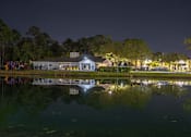 Thumbnail 41 of 49 - A building is reflected in the water at night.