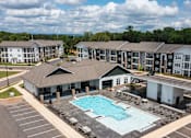 Thumbnail 1 of 21 - A large building complex with a pool in the foreground.
