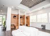 Thumbnail 5 of 32 - A white couch is in the middle of a room with a wooden wall and a ceiling with a pattern.