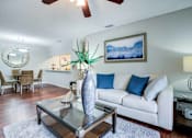 Thumbnail 9 of 26 - A living room with a white couch and a glass coffee table at Coral Club Apartments in Bradenton, FL