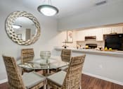 Thumbnail 7 of 26 - A dining room with a glass table and chairs at Coral Club Apartments in Bradenton, FL