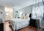 Thumbnail 14 of 26 - A bedroom with a large bed and a plant at Coral Club Apartments in Bradenton, FL
