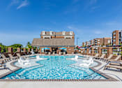 Thumbnail 19 of 28 - A large swimming pool with a building in the background.