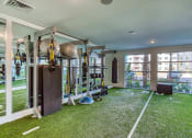 Thumbnail 16 of 34 - Pet-Friendly Apartments in Maitland, FL - Parker at Maitland Station - Crossfit Room of 24-hour Fitness Center with Artificial Turf, Weights, Equipment, Mirror Wall, Large Windows, and Punching Bag