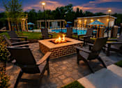 Thumbnail 31 of 35 - A fire pit in the middle of a patio surrounded by chairs.