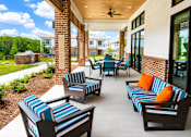 Thumbnail 27 of 35 - A patio with striped cushions and chairs.