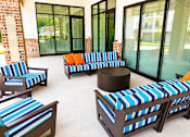 Thumbnail 26 of 35 - A set of outdoor furniture with blue and white striped cushions.