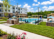 Thumbnail 29 of 35 - A pool surrounded by a black fence and a building in the background.