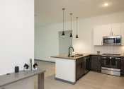 Thumbnail 29 of 47 - Modern kitchen in a Florida apartment featuring an island, stove, and microwave.