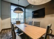 Thumbnail 13 of 56 - a meeting room with a large window and a wooden table and chairs