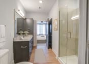 Thumbnail 47 of 56 - a bathroom with a shower and sink and a door to a bedroom