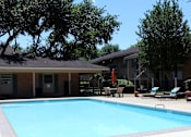 Thumbnail 20 of 21 - A swimming pool surrounded by beautiful trees makes for a tranquil experience.