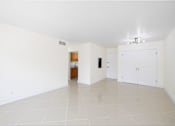 Thumbnail 9 of 22 - A spacious room with white walls and a tiled floor.