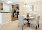 Thumbnail 8 of 32 - A kitchen with a dining table and chairs.