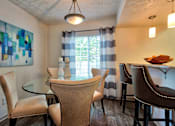 Thumbnail 7 of 35 - A dining room with a glass table and chairs.