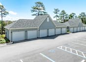 Thumbnail 43 of 48 - A large grey building with a parking lot in front.