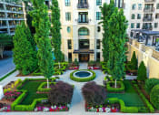 Thumbnail 53 of 58 - a courtyard with trees and flowers in front of a building