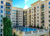 Thumbnail 33 of 58 - an exterior view of an apartment building with a large swimming pool