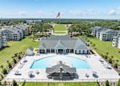 Thumbnail 1 of 48 - A large building with a pool in front of it.