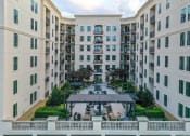 Thumbnail 54 of 58 - Buckhead, GA, Luxury Apartments - 92 West Paces - White Building Exterior with Outdoor Courtyard, Hedges, Cafe Lights, Lounge Seating, Fire Pits, Tables and Chairs, Grill Stations, and Pergola.