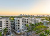 Thumbnail 37 of 38 - an aerial view of apartment buildings with palm trees and a city skyline in the background