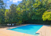 Thumbnail 25 of 35 - a swimming pool with trees in the background