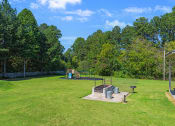 Thumbnail 30 of 35 - a park with a playground and a fire pit