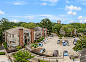 Thumbnail 37 of 38 - A view of a parking lot with cars and apartment buildings.