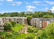 Thumbnail 33 of 38 - Apartment complex with a green lawn in the middle.