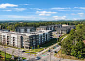 Thumbnail 40 of 41 - A large building complex surrounded by trees and a parking lot.
