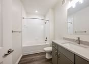 Thumbnail 19 of 35 - A white bathroom with a toilet, sink, and bathtub.