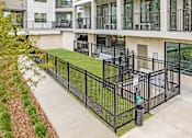 Thumbnail 53 of 54 - A black metal fence surrounds a green lawn in front of a building.