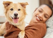 Thumbnail 43 of 46 - A man is holding a happy dog in his arms.
