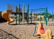 Thumbnail 29 of 51 - A playground with a yellow slide and a green monkey bar.
