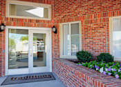 Thumbnail 36 of 51 - A red brick building with a glass door and window.
