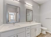 Thumbnail 28 of 31 - A bathroom with a white countertop and a large mirror above it.