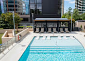 Thumbnail 51 of 72 - A large outdoor swimming pool with a diving board and lounge chairs.